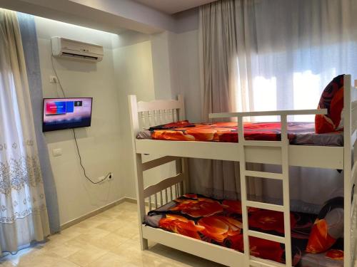 1 Schlafzimmer mit 2 Etagenbetten und einem TV in der Unterkunft Floger world in Vlorë