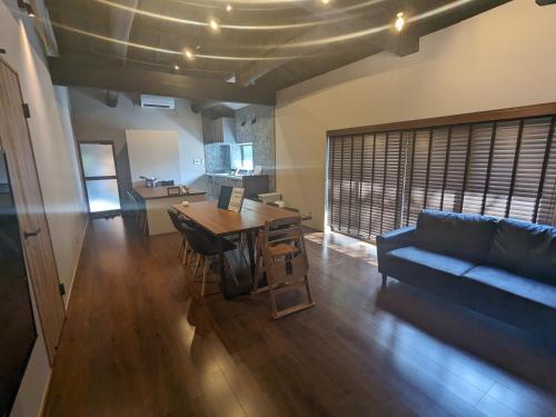 a living room with a table and a couch at LOOP-shiso 宍粟市BBQとサウナでととのう天空回廊にたたずむ貸別荘 in Shiso