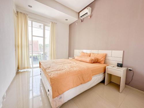 - une chambre avec un lit doté de draps orange et une fenêtre dans l'établissement Villa Kalimaya - 3 Bedrooms, à Dau