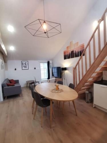 un salon avec une table et un escalier dans l'établissement 4 pièces centre-ville Bourg-en-Bresse, à Bourg-en-Bresse