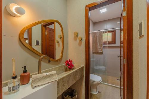 a bathroom with a sink and a toilet and a mirror at Chalé Alto da Bela Vista por Carpediem in Guaramiranga