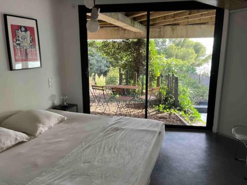 una camera da letto con un letto e vista sul patio di Loft sur le Mont Saint Clair - Sète a Sète