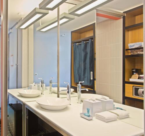 a bathroom with two sinks and a large mirror at Aloft Birmingham Soho Square in Homewood