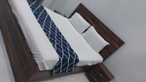 a bed with a wooden headboard with a tie on it at Hotel Elegant Gulshan-e-Iqbal karachi in Karachi