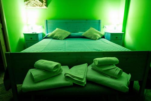 a green bedroom with a bed with green sheets and pillows at RhelizeOne & Spa جميل in Palermo
