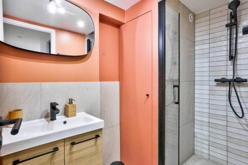 y baño con lavabo y ducha con espejo. en Magnifique appartement pour 6 - Montorgueil, en París