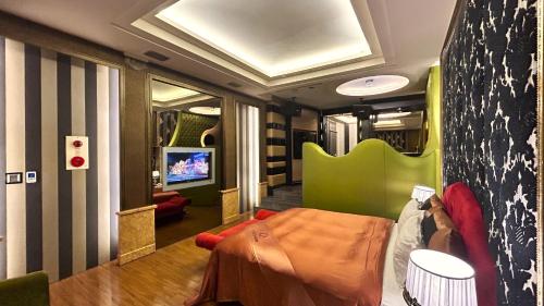 a train room with a bed and a tv at Shining Motel in Taichung