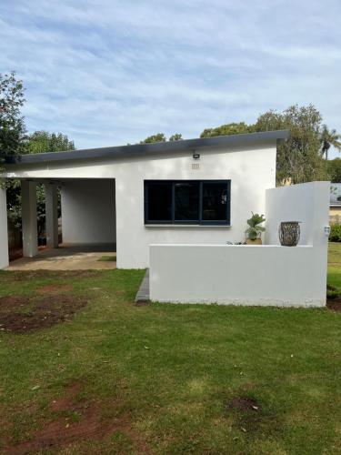 a white house with a window in a yard at Market on 5 in Piet Retief