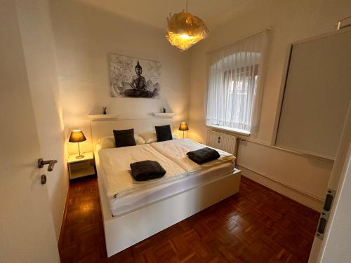 1 dormitorio con 1 cama blanca grande y 2 lámparas en Ferienwohnung Anna, en Burgau