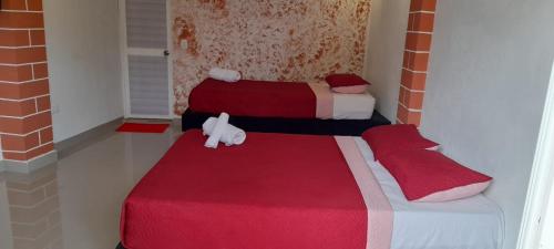 聖安德烈斯的住宿－POSADA HIGH TIDE，一间设有两张红色和白色毯子的房间