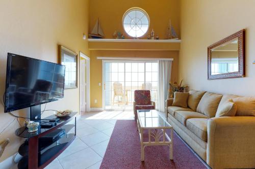 a living room with a couch and a flat screen tv at Dawn Condominiums - Break of Dawn in Galveston