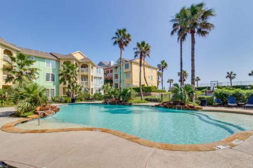 a large swimming pool with palm trees and condos at Dawn Condominiums - Break of Dawn in Galveston