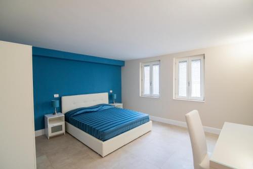 a bedroom with a blue accent wall and a bed at La Finestra Sul Vulcano in Roccamonfina