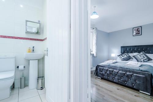 a bedroom with a bed and a toilet and a sink at Home Away Apartment in Manchester