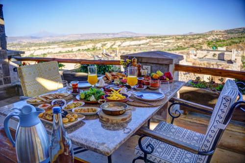 a table with food and drinks on a balcony at Petra Inn Cappadocia Luxury in Uchisar