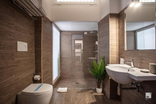 uma casa de banho com um lavatório, um WC e um espelho. em Hotel Boutique Nazionale em Roma
