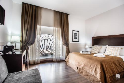 Un dormitorio con una cama grande y una ventana. en Hotel Boutique Nazionale, en Roma