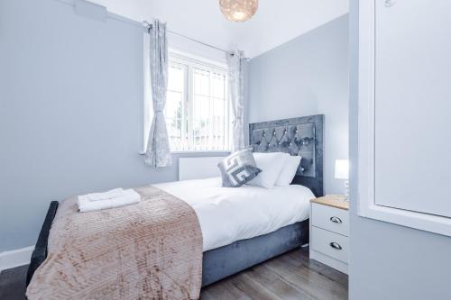 a bedroom with a large bed and a window at Home Away Apartment in Manchester