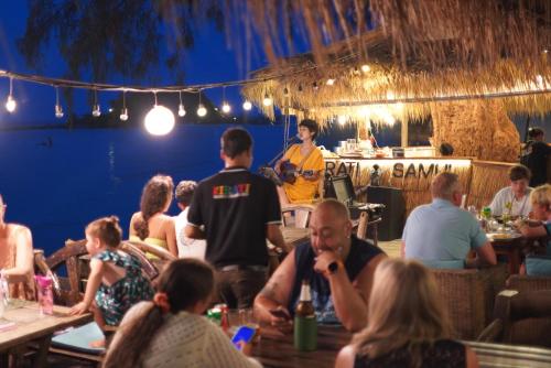 a group of people sitting at tables in a restaurant at Kirati Beach Resort in Choeng Mon Beach