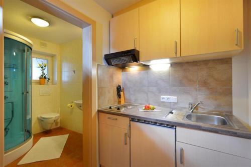 a kitchen with yellow cabinets and a sink and a toilet at Ferienhaus AB in Söll
