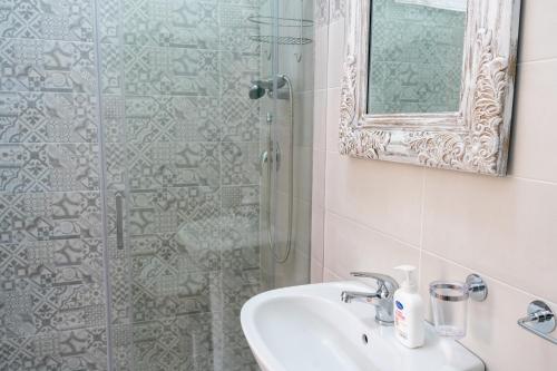 a bathroom with a sink and a shower with a mirror at Gennaro Holidays in Corleone
