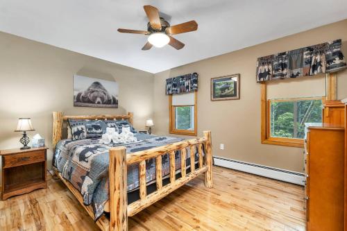 um quarto com uma cama de madeira e uma ventoinha de tecto em Bears Den em Rumney
