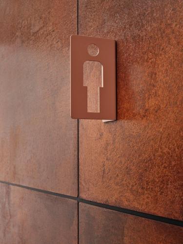 a sign on a brick wall with a key on it at CityHub Amsterdam in Amsterdam