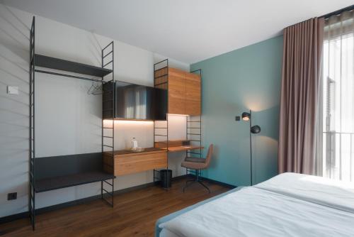 a bedroom with a bed and a desk and a chair at EmiLu Design Hotel in Stuttgart