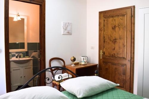 a bedroom with a bed and a sink and a door at IL GINEPRO B&B in Piamaggio