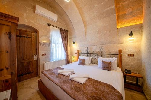 a bedroom with a bed with two towels on it at Roma Cave Suite in Goreme