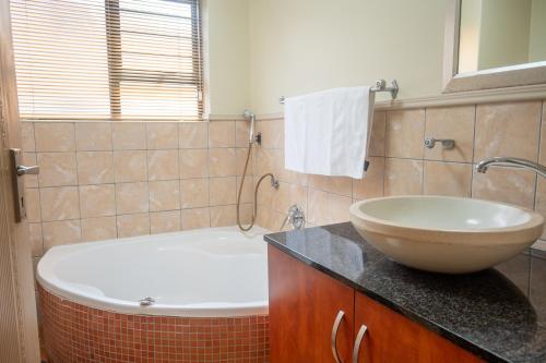 a bathroom with a sink and a bath tub at Premium Getaway @ la Bella Costa in Pretoria