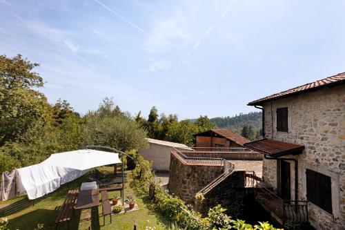 a patio with an umbrella and a building at La Casina di Nella in Gavedo