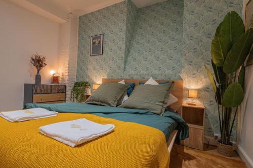 une chambre avec un lit avec deux serviettes dessus dans l'établissement Unique MontmartreSacré-Cœur appartement Parking, à Paris