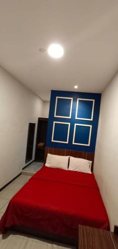 una camera con letto rosso e finestra di Bromo Family Guest House a Kepanjen