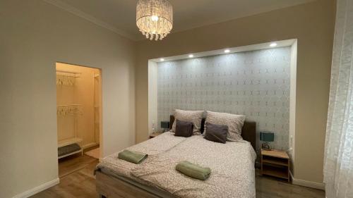 a bedroom with a large bed and a chandelier at Buda Garden Apartment in Budapest