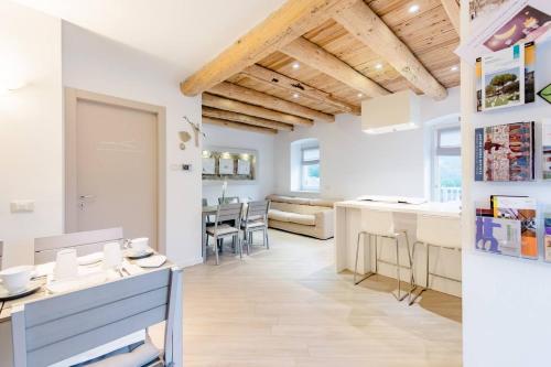 a kitchen and dining room with white walls and wooden ceilings at B&B Il Piccolo Principe room and breakfast in Bieno