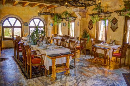 un restaurante con mesas y sillas en una habitación en Petra Inn Cappadocia en Uchisar