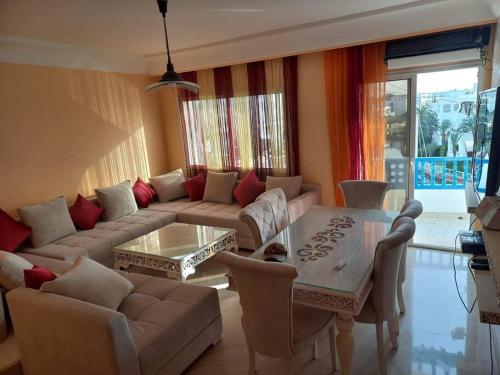 a living room with a couch and a table at Appartement de luxe au coeur de la marina Hammamet in Hammamet
