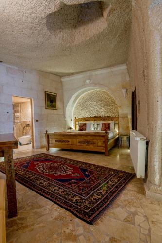 a bedroom with a large bed and a large rug at Roma Cave Suite in Goreme