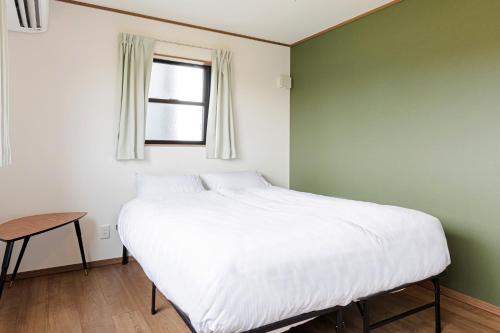 a bedroom with a white bed and a window at 三浦海岸 SealightVilla A棟 in Miura