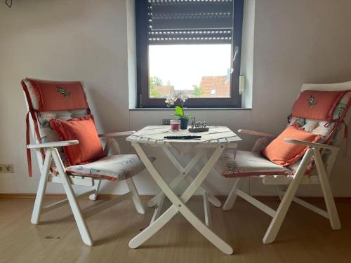 a table and two chairs in a room with a window at Gemütliche Wohnung in ruhiger Lage in Karlsruhe