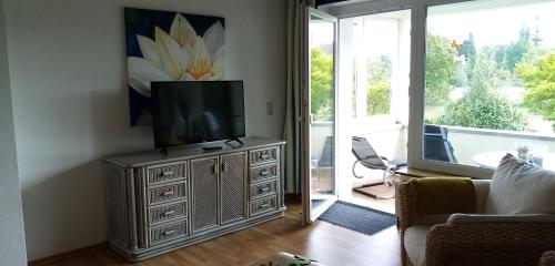 uma sala de estar com uma televisão numa cómoda com um sofá em Fewo Summertime em Hehlen