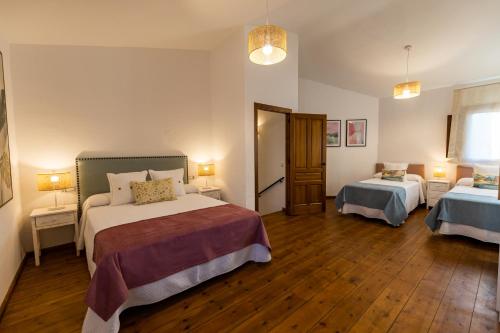 una camera d'albergo con due letti e due lampade di Apartamentos Rurales la Campiña a Casiñas Bajas