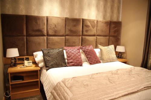 a bedroom with a large bed with a large padded headboard at The Royal Hotel in Cookstown