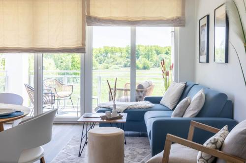 a living room with a blue couch and a table at Weiße Villen "das Meeresloft" in Boltenhagen