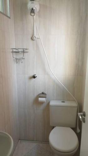 a bathroom with a white toilet and a sink at Aconchegante apt c/ garagem in Serra Negra
