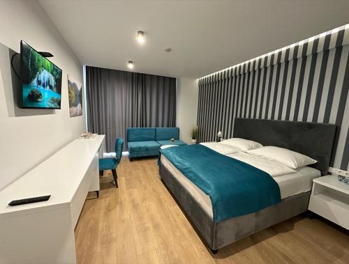 a bedroom with a bed and a desk and chairs at Hotel GOLD JET Bihać in Bihać