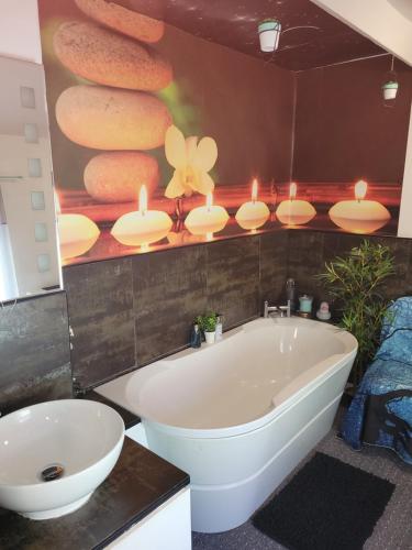 a bathroom with a white tub and a painting of donuts at No 35 Guisborough - 2 bedroom house in Guisborough