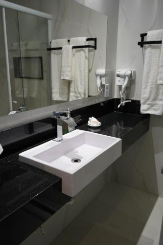 a bathroom with a white sink and a mirror at Pousada Granja Santa Barbara in Petrópolis
