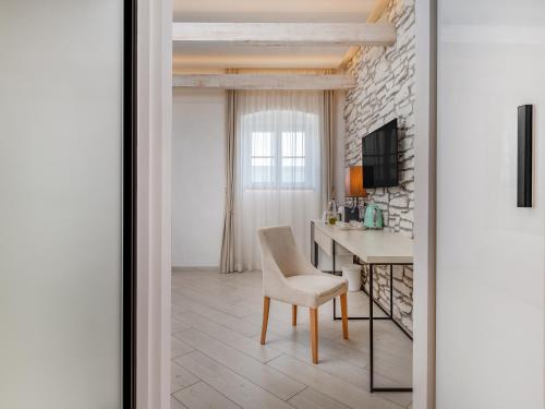 a room with a table and a chair and a desk at Lazure Hotel & Marina in Herceg-Novi
